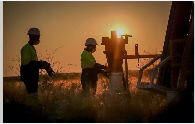 Drill crew working an RC rig at sunset